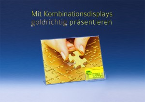 Mit Kombinationsdisplays präsentieren Sie Ihre Informationen goldrichtig! Auf der Abbildung ist ein querformatiges Kombinationsdisplay vor blauem Grund zu sehen. Der Werbeaufsteller enthält ein Poster, auf dem eine Hand zu sehen ist, die ein goldenes Puzzle mit dem letzten Puzzleteil vervollständigt. An den Werbeaufsteller angebracht ist ein Visitenkartenfach. Angelehnt an das Motiv des Werbeposters im Aufsteller sind die Visitenkarten in einem ähnlichen Farbton gehalten. Zudem spiegelt sich das grafische Element des Puzzlestücks auf den Visitenkarten wieder. Auf dem blauen Hintergrund ist der Schriftzug "Mit Kombinationsdisplays goldrichtig präsentieren" zu lesen. Dieser lehnt sich an den Text des Beitrages an. Hier wird zunächst eine Studie skizziert, die vom Rückgang des Interesses an Luxusgütern berichtet. Unter Bezug auf den Anstieg der Dienstleistungen wird argumentiert, dass zum Beispiel an Infotheken und Rezeptionstresen Kombinationsdisplays sinnvoll platziert sind. Diese versorgen Interessierte stets mit wichtigen Informationen, die sie sich auch mitnehmen können.