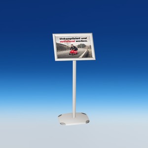Vor einem blauen Hintergrund ist ein Infoständer mit aufgesetztem Klapprahmen aufgestellt. In dem Wechselrahmen im Querformat ist eine Abbildung eingeschoben, auf der ein Mann im Anzug auf einem roten Rutschauto zu sehen, der damit eine Straße befährt. Der Druck trägt den Titel "Unkompliziert und auffallend werben".