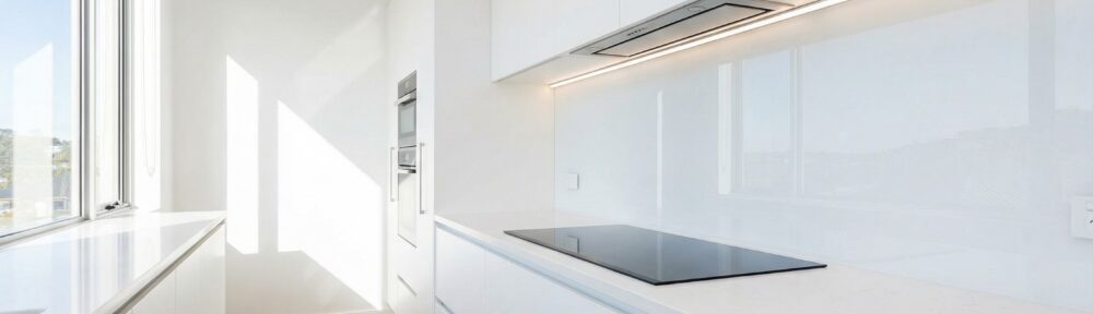 Moderne Küche mit fugenloser Küchenrückwand aus weißem Plexiglas und Induktionsherd