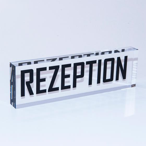 Massiver PLEXIGLAS® Block mit Aufdruck „Rezeption“