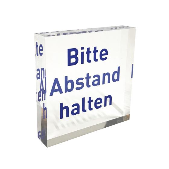 Transparenter PLEXIGLAS® Block als Hinweis-Aufsteller mit blauem Aufdruck „Abstand halten“